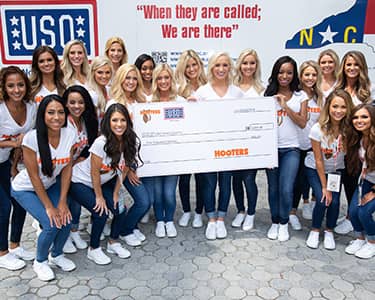 Hooters Girls assisting in a donation to the USO